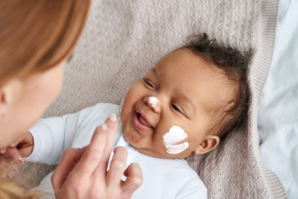 mother applying cream to baby