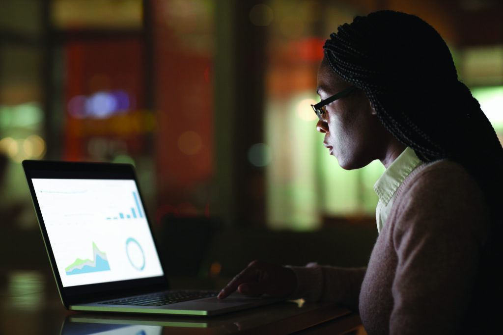 Woman viewing laptop screen at night